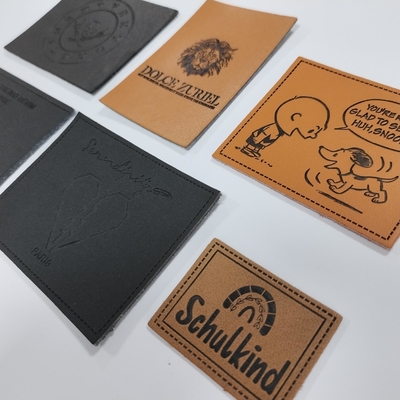 Microfiber a gravé le label en refief en cuir d'unité centrale de logo cousent sur l'habillement adaptent la conception aux besoins du client