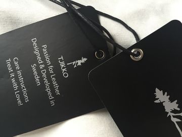 Les deux étiquettes de coup d'habillement de papier d'art de logo d'argent de côté avec la corde cirée par noir