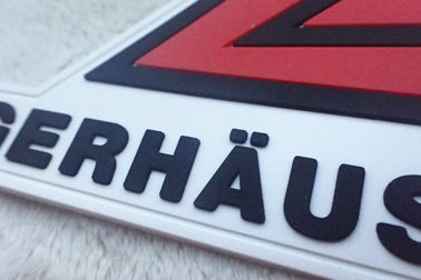 Le rouge et le blanc ont gravé des insignes en refief de silicium ont adapté les corrections aux besoins du client en caoutchouc molles de PVC de logos