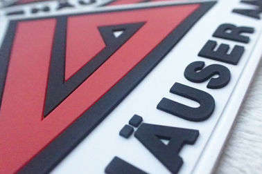 Le rouge et le blanc ont gravé des insignes en refief de silicium ont adapté les corrections aux besoins du client en caoutchouc molles de PVC de logos