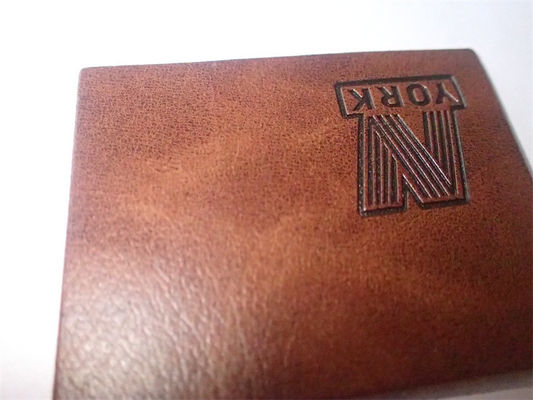 L'habillement en cuir fait sur commande de conception de label a gravé les corrections en refief en cuir pour le vêtement