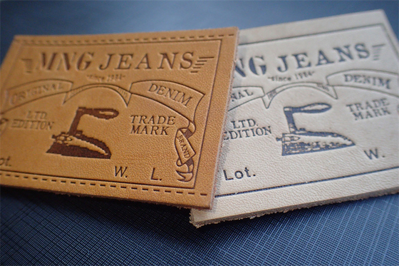 Les jeans écologiques garnissent en cuir des labels de correction ont gravé Logo For Uniform en refief