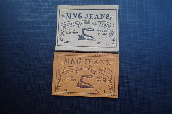 Les jeans écologiques garnissent en cuir des labels de correction ont gravé Logo For Uniform en refief