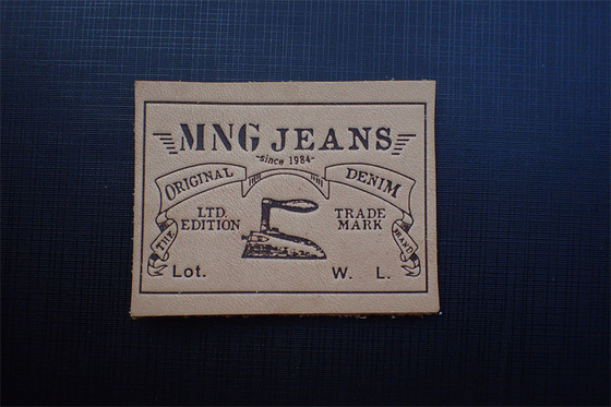 Les jeans écologiques garnissent en cuir des labels de correction ont gravé Logo For Uniform en refief
