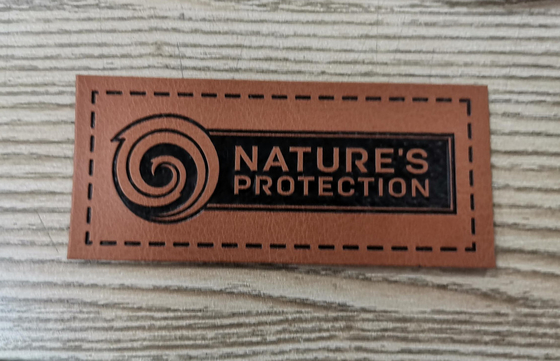 Les labels de vêtement ont gravé la correction en refief en cuir cousent sur le logo d'unité centrale d'habillement